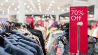 Prismarkedsføring - udsalg - nedsatte varer - procent rødt skilt i tøjforretning 